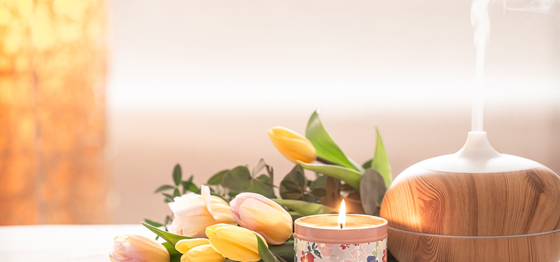 Candle and flowers with a diffuser on a blurred background